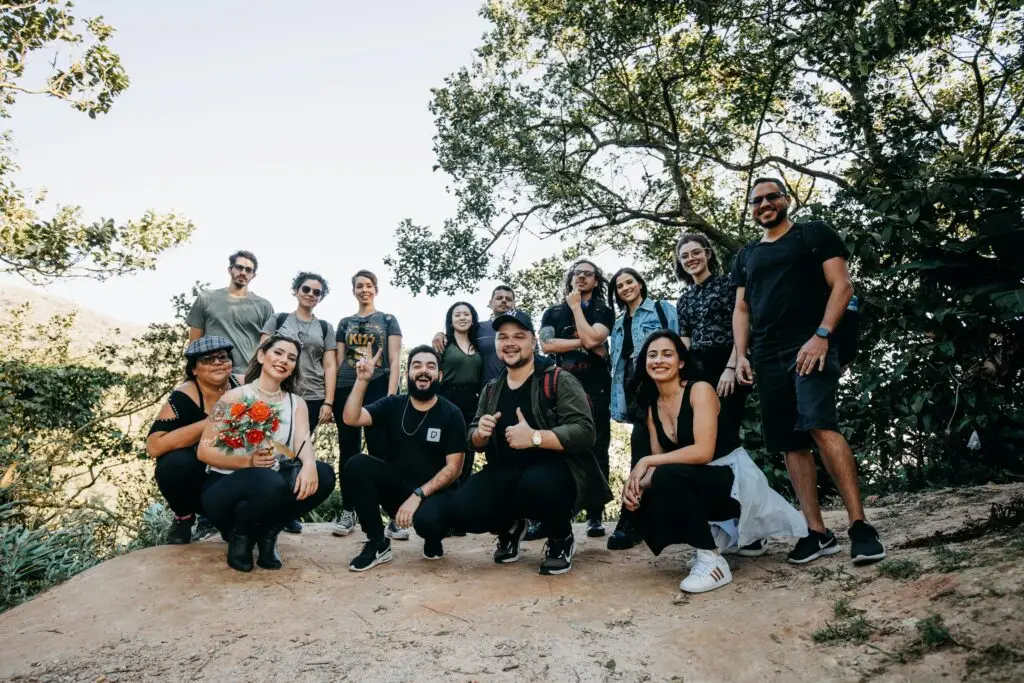 A diverse group of friends posing together on a hiking trip in the woods, enjoying a sunny day.